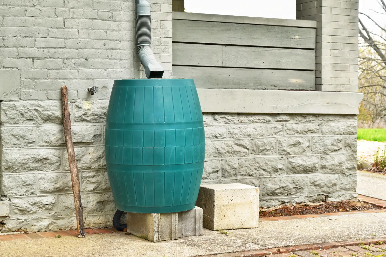 Récupérateur d'eau de pluie branché sur la descente de gouttière d'une maison